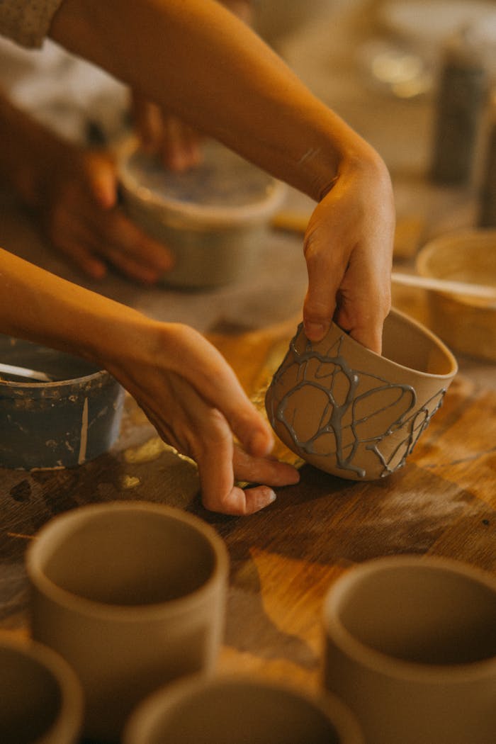 why-choose-us Artisan shaping ceramic pottery in a creative workshop setting.